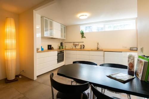a kitchen with a black table and chairs in a kitchen at Smart Luxury - Gaming Arena, Gym, Sauna and Jacuzzi in Keflavík