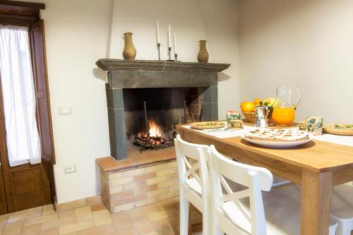a dining room with a table and a fireplace at La Finestra su Civita in Lubriano