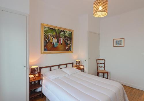 une chambre avec un lit blanc et un tableau au mur dans l'établissement le FAMILY LODGE 2 chambres 4 personnes classe 3 etoiles, à Annecy