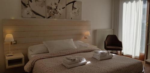 a bedroom with a bed with two towels on it at Garni San Lorenzo in Pinzolo