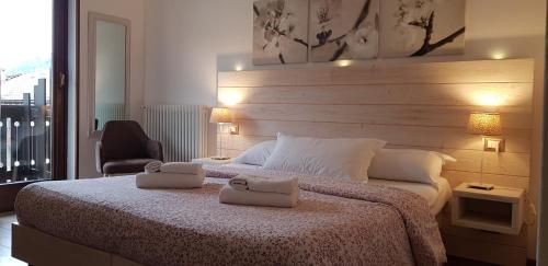 ピンツォーロにあるGarni San Lorenzoのベッドルーム1室(ベッド1台、タオル2枚付)