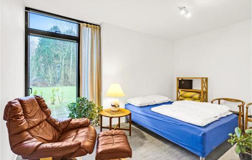 um quarto com uma cama, uma cadeira e uma janela em Villa Hideaway em Tranekær