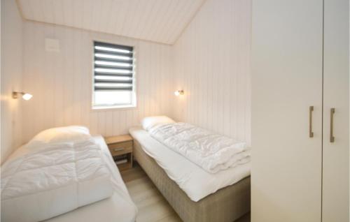 Bøtø ByにあるBeautiful Home In Vggerlse With Sauna, Wifi And Heated Swimming Poolのベッド2台と窓が備わる小さな客室です。