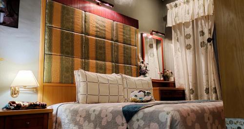 Kampong Bukit Katil的住宿－Faridah Homestay Melaka Muslim Friendly，一间卧室配有一张带大型木制床头板的床