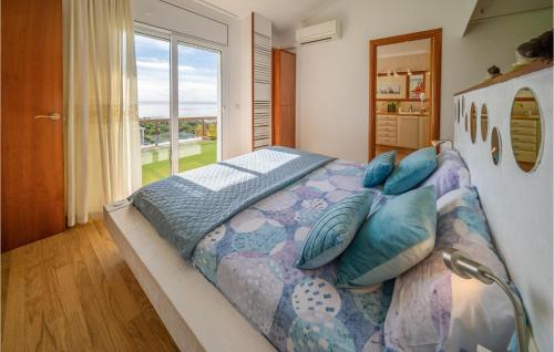 1 dormitorio con 1 cama grande con almohadas y ventana en Lovely Home In Malgrat De Mar With Swimming Pool, en Malgrat de Mar