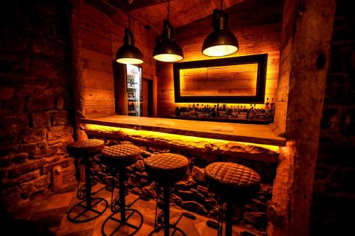 a room with a bar with stools and a mirror at Hotel Xaluca Spa Aguelmame Sidi Ali in Aguelman