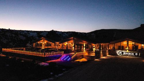 a building with lights in front of it at night at Hotel Xaluca Spa Aguelmame Sidi Ali in Aguelman