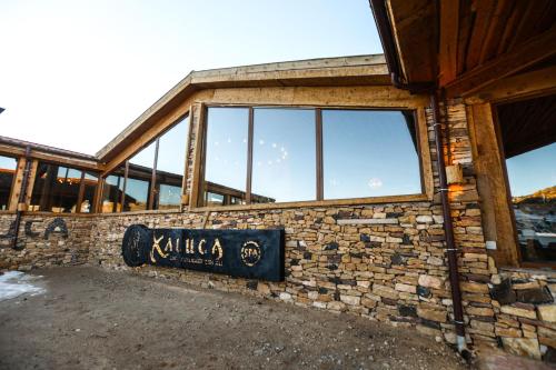 a building with a sign on the side of it at Hotel Xaluca Spa Aguelmame Sidi Ali in Aguelman