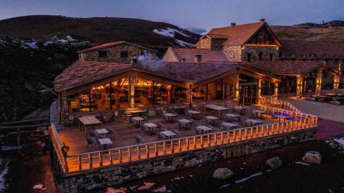 a large building with a deck with chairs and tables at Hotel Xaluca Spa Aguelmame Sidi Ali in Aguelman