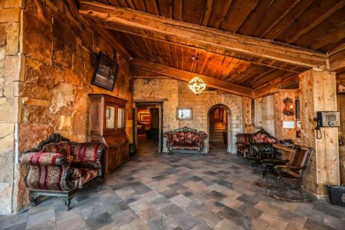 a living room with chairs and a stone wall at Hotel Xaluca Spa Aguelmame Sidi Ali in Aguelman