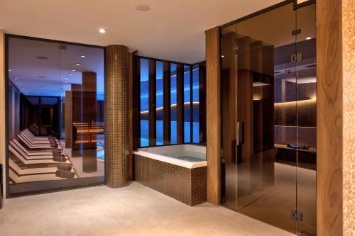 a bathroom with a tub and a walk in shower at Bijele Vode spa&nature hotel in Prijedor