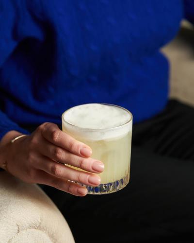 a person is holding a glass of milk at Hotel Nerudova 211 in Prague