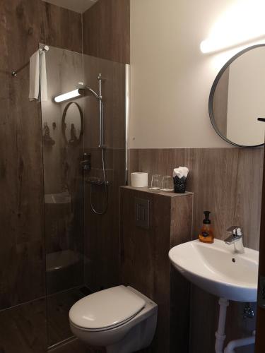 a bathroom with a shower and a toilet and a sink at Vík Inn in Vík