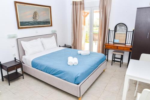 a bedroom with a bed with blue sheets and a piano at Donna Dorato in Finikounta