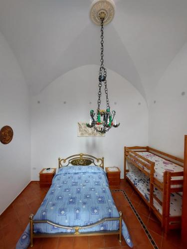 a bedroom with two beds and a chandelier at Casa Muse in Maiori