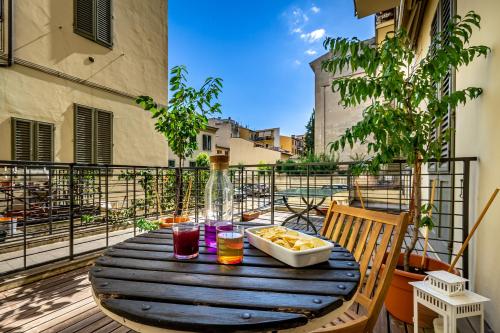 a wooden table with a bowl of food on a balcony at Luxury apt in the heart of city out of ZTL in Florence