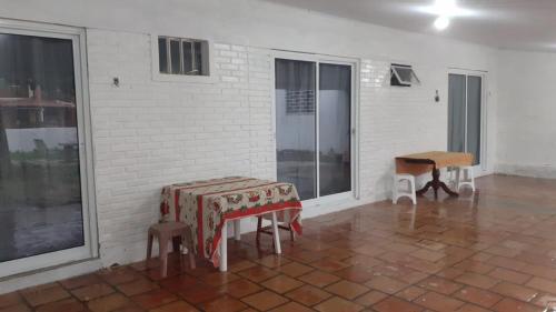 Cette chambre comprend une table, des chaises et des fenêtres. dans l'établissement Suíte a duas quadras da Praia e perto da Ilha do Mel, à Pontal do Paraná