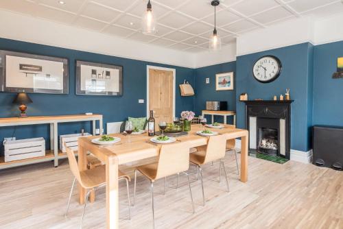 a dining room with a table and chairs and a clock at 3 St Nicholas Court, Aldeburgh in Aldeburgh