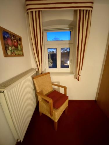 a chair sitting in a room with a window at Privatquartier van Dreuten in Warpe
