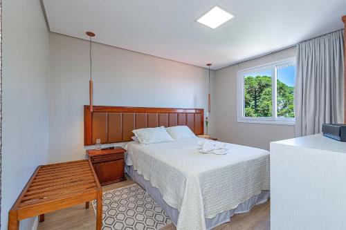 a bedroom with a bed and a window at Café da Banca - Stay House Temporada in Gramado