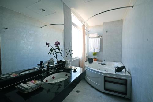 a bathroom with a tub and a sink and a bath tub at Romance Hotel in Hue