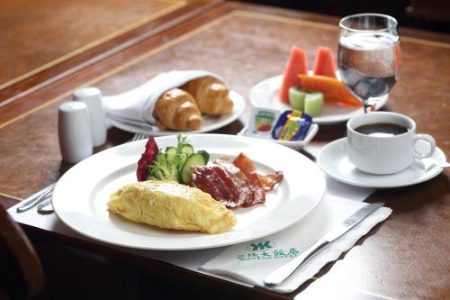 Santos Hotel في تايبيه: طاولة مع أطباق من الطعام وكوب من القهوة