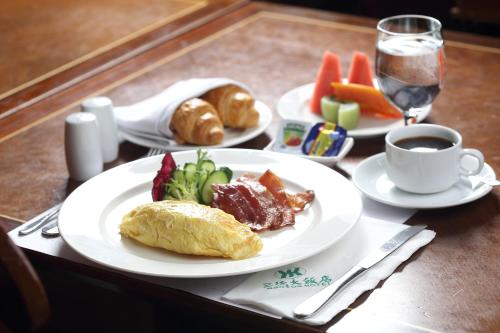 a table with plates of food and a cup of coffee at Santos Hotel in Taipei