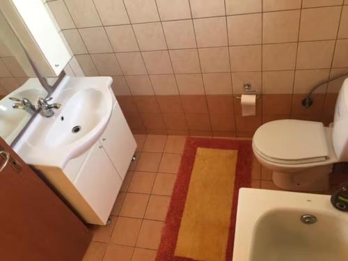 a bathroom with a sink and a toilet and a tub at Sunshine Villa in Stoupa