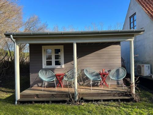 a group of chairs and a table on a deck at A true nature pearl in idyllic surroundings but close to the city in Holbæk