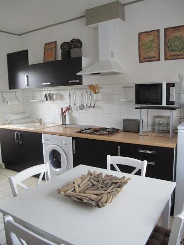 une cuisine avec une table blanche et un comptoir blanc dans l'établissement Maison de vacances La Palue entre plage et centre bourg, au Guilvinec