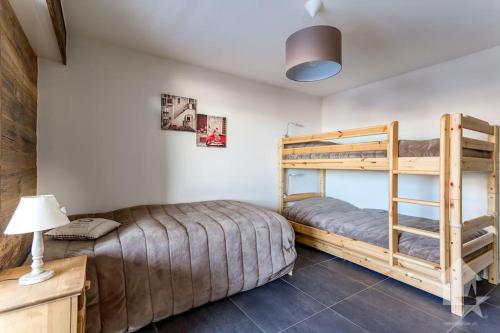 a bedroom with two bunk beds and a lamp at Appartement Rosalp, 200m des télécabines, in Nendaz