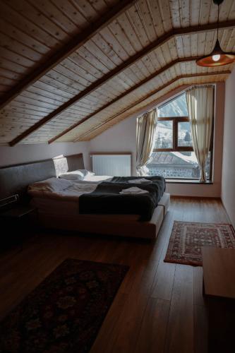a bedroom with a bed and a large window at Paramount Kazbegi in Stepantsminda