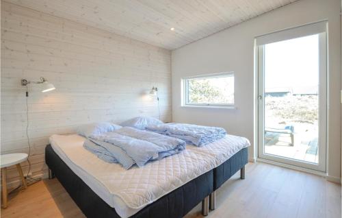 Un dormitorio con una cama con almohadas azules. en Lovely Home In Thisted With Kitchen, en Thisted