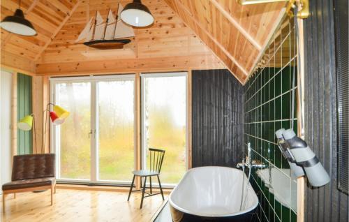baño con bañera, silla y ventana en Lovely Home In Ebeltoft With House Sea View, en Ebeltoft
