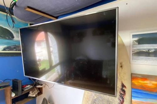 TV de pantalla plana grande colgada en la pared en Andy House hospedaje en Mar del Plata