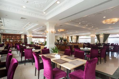 a dining room with tables and purple chairs at Regency Angkor Hotel in Siem Reap