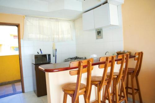 uma cozinha com um balcão com cadeiras e uma mesa em Hermoso y cómodo apartaestudio! em Barranquilla