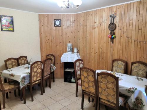 uma sala de jantar com mesas e cadeiras e um relógio na parede em Oskolok Dovbusha Mini-Hotel em Yaremche