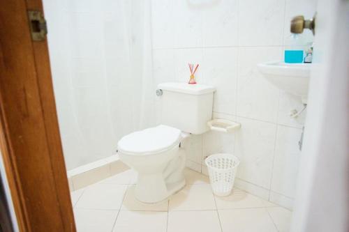 Baño blanco con aseo y lavamanos en Hermoso y cómodo apartaestudio!, en Barranquilla