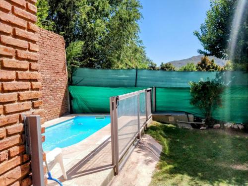 a swimming pool with a fence next to a backyard at La Casa de Las Flores Potrero de los Funes in Potrero de los Funes