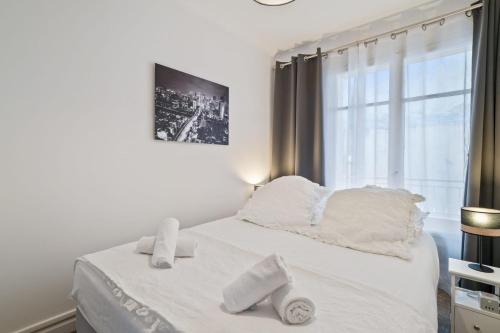 - un lit blanc avec des oreillers blancs et une fenêtre dans l'établissement Appartement Sauvalie - Welkeys, au Cannet