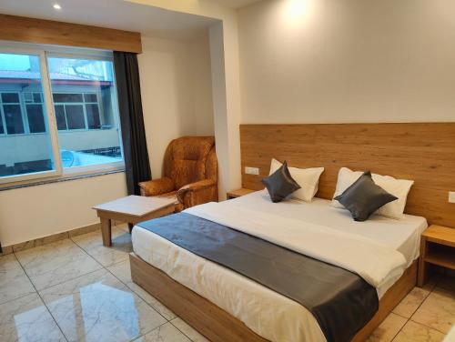 1 dormitorio con 1 cama, 1 silla y 1 ventana en Sonu Guesthouse & Hostel en Rishīkesh