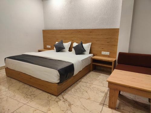 a bedroom with a large bed and a chair at Sonu Guesthouse & Hostel in Rishīkesh