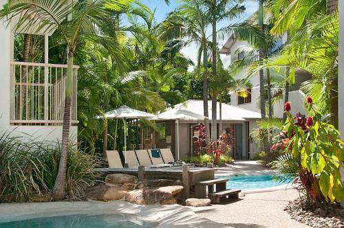 ein Resort mit einem Pool und einem Haus mit Palmen in der Unterkunft Offshore Noosa Resort in Noosaville