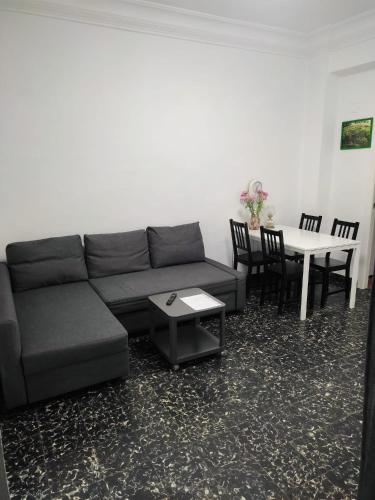Apartamento Cuatro Carreres في فالنسيا: غرفة معيشة مع أريكة وطاولة