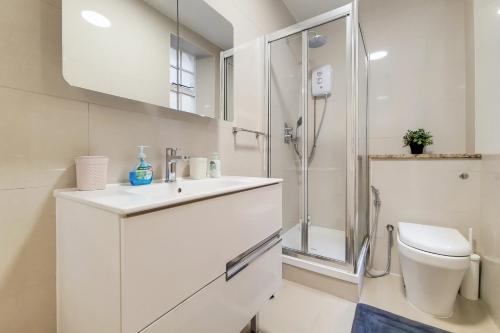 a white bathroom with a toilet and a shower at The Quebec Residence in London