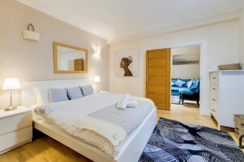 - une chambre avec un grand lit blanc et une commode dans l'établissement The Quebec Residence, à Londres