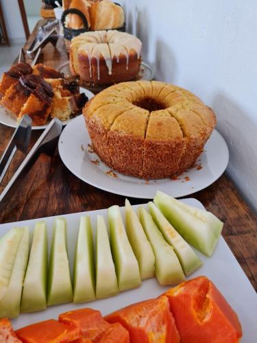 a table topped with plates of food and a cake at Pousada Girassol da Ferrugem in Garopaba