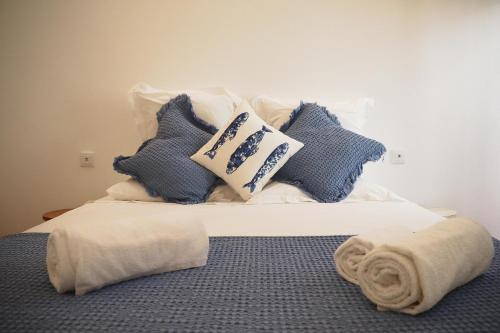 a bed with blue and white pillows on it at So Sweet Center of Faro Flat in Faro