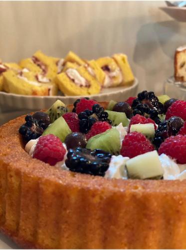 a cake with fruit on top of it with other desserts at B&B Panorama Cinque in Salò